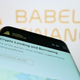 Mobile phone with website of crypto company Babel Finance on screen in front of business logo